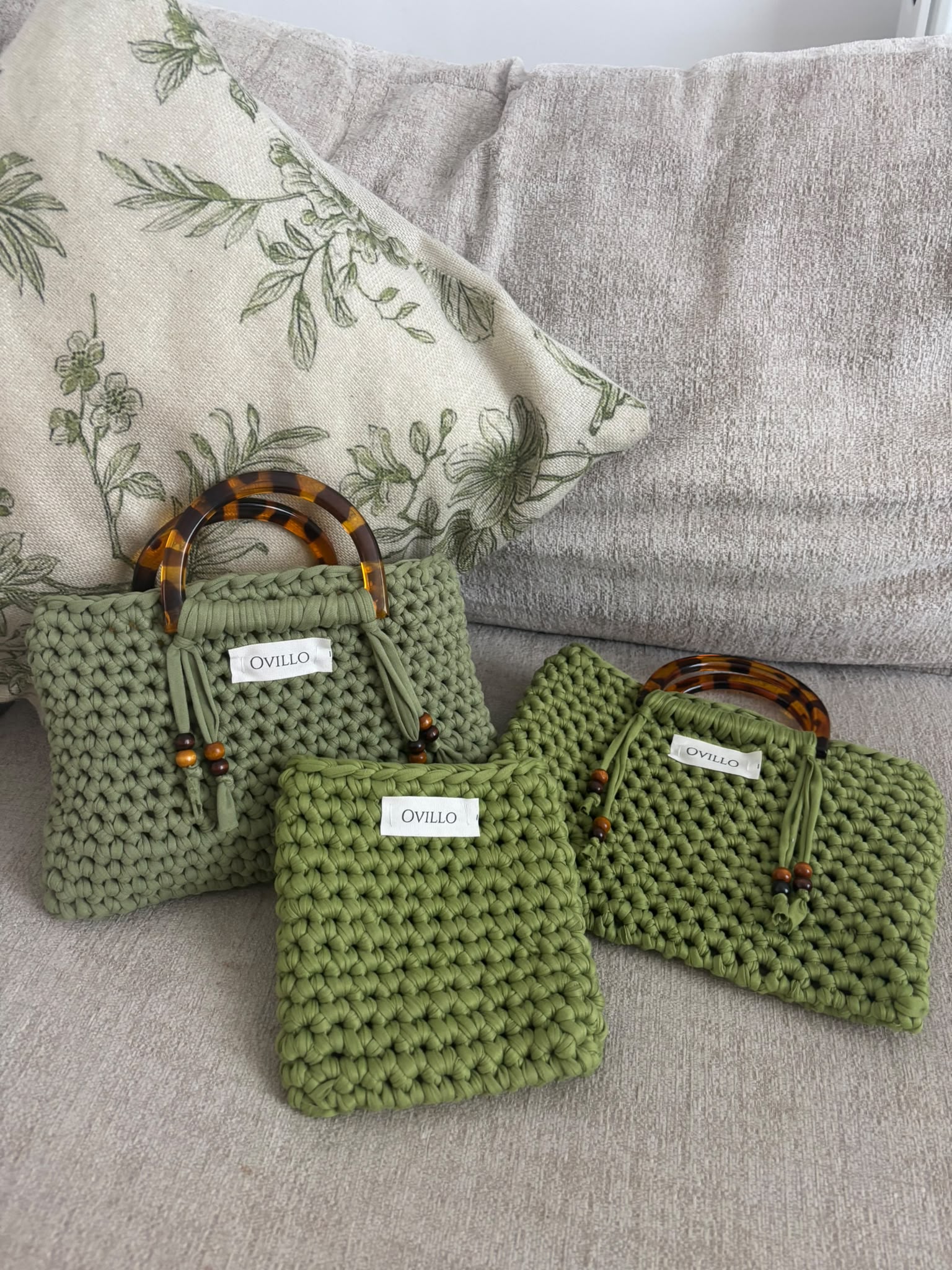 A collection of three green hand-crocheted Ovillo bags