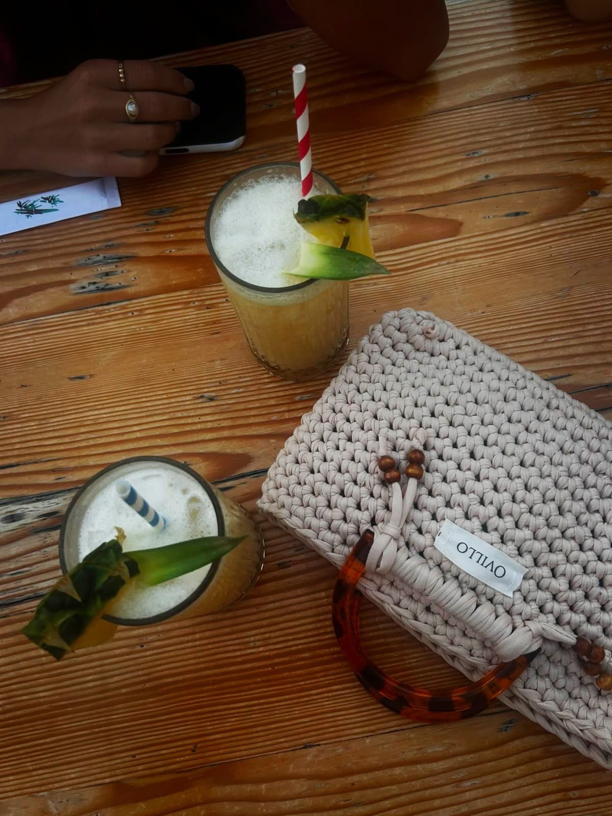 Cream hand-crocheted tote beside two drinks
